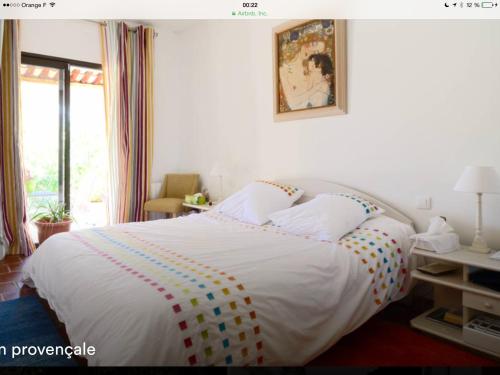 a bedroom with a large white bed with colorful pillows at Lou Parpaillou in Éguilles