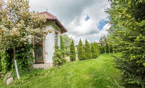 a small house in a yard with green grass at Domek na końcu świata in Szymbark