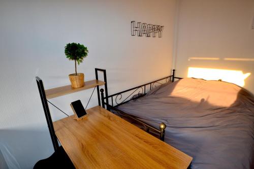 a bedroom with a bed and a plant on a table at Capstay famars & Netflix in Famars