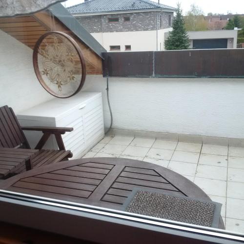 a patio with a wheel and a chair on a roof at Apartmán v rodinném domě in Hradec Králové