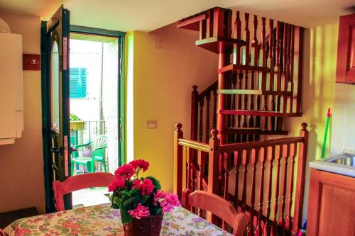 a dining room with a table with a vase of flowers at Da Greta - Biassa in La Spezia