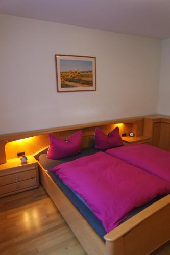 a bedroom with a large bed with purple sheets at Ferienwohnung "Hedwig" in Bad Saarow
