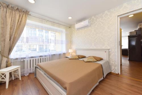 a bedroom with a bed and a large window at Baltieji Senamiesčio Apartamentai prie Aqua Parko in Druskininkai