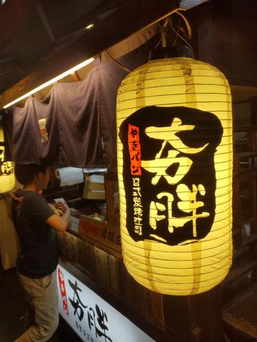 a man standing next to a lantern with a sign on it at 台南星鑽國際商旅 Hua Hotel in Tainan