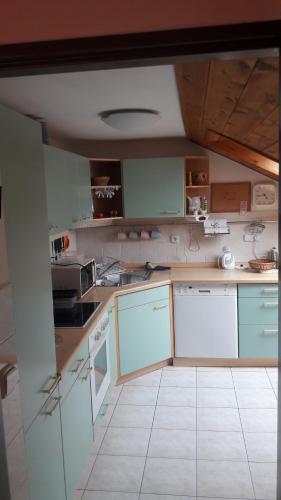 a kitchen with blue cabinets and a white tile floor at Apartmán v rodinném domě in Hradec Králové