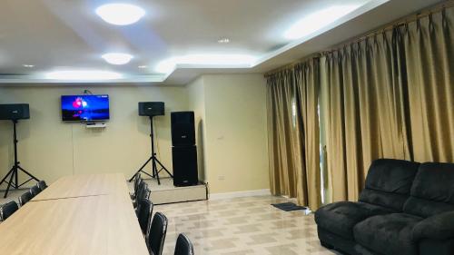 a conference room with a table and a couch and a television at Panutsaya Homestay in Wang Nam Khieo