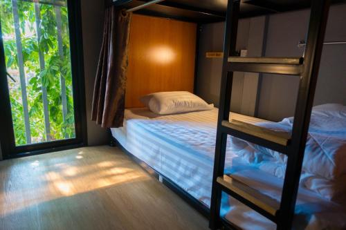 a bedroom with a bunk bed and a window at Comfy Bed Hostel in Bangkok