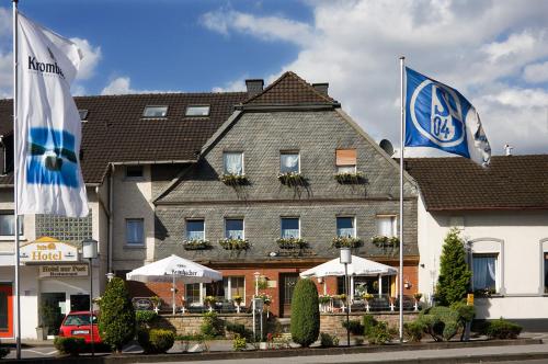 a hotel with two flags in front of a building at Hotel zur Post in Arnsberg