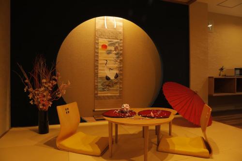 un salon avec une table, des chaises et une table sidx sidx sidx dans l'établissement Guesthouse Raku, à Kyoto