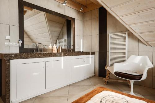 - une cuisine avec des placards blancs et une chaise blanche dans l'établissement Kwiat Śniegu DeLuxe Koło Gubałówki, à Nowe Bystre