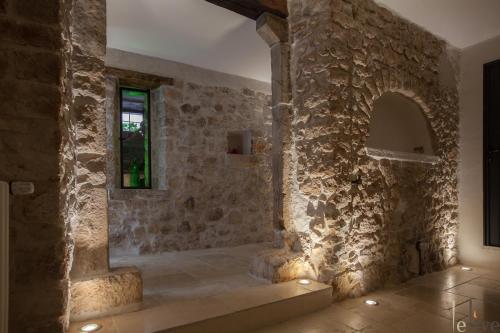 Cette chambre en pierre est dotée d'un mur en pierre et d'une fenêtre. dans l'établissement Lelive Bed and Breakfast, à Sermoneta