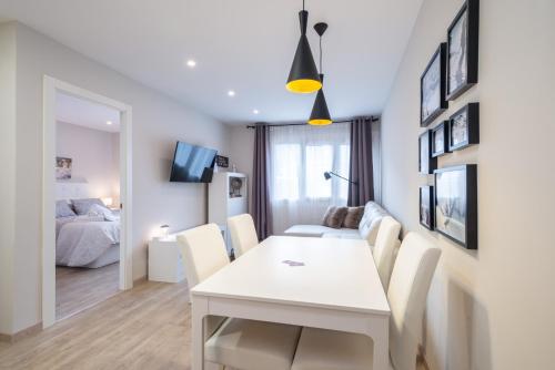 a dining room with a white table and chairs and a bedroom at LA PETITE MAISON DE SUSANNA in Pas de la Casa