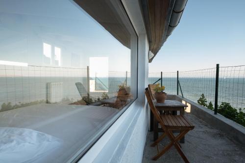 a balcony with a bed and a table and the ocean at Property on Seacliff with the Beach downstairs in Arnao