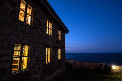 a building with a view of the ocean at night at Property on Seacliff with the Beach downstairs in Arnao