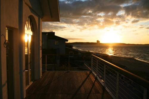 a sunset from the balcony of a house at Strandhuus - Urlaub aan de Ostsee in Timmendorfer Strand