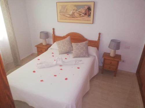 コラレホにあるApartamento Muelle de Corralejo 9のベッドルーム1室(花が咲く白いベッド1台付)