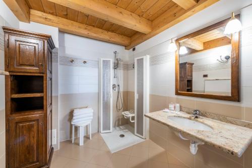 uma casa de banho com um lavatório e um chuveiro em Hotel L' Aiglon em Champoluc