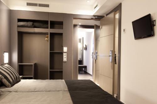 une chambre avec un lit et une télévision à écran plat dans l'établissement Dalia Ramblas, à Barcelone