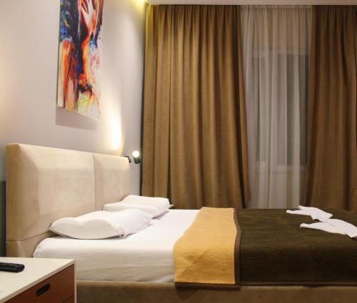 a hotel room with a bed with white pillows at Star Hotel in Tirana