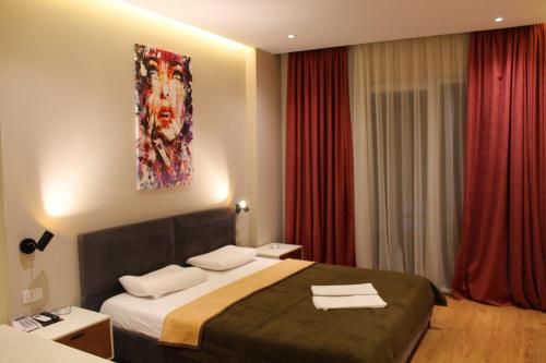 a hotel room with a bed and a painting on the wall at Star Hotel in Tirana