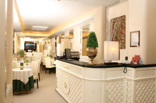 un ristorante con bancone, tavoli e sedie di Hotel Valle a Roma