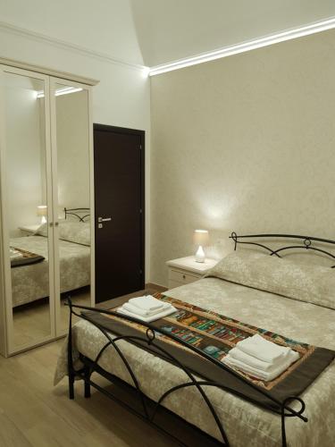 una camera con un letto e un grande specchio di B&B da Mammina a Taranto
