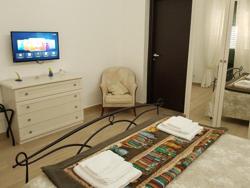 una camera con letto, TV e sedia di B&B da Mammina a Taranto