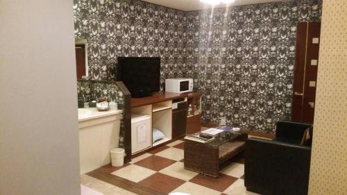 um quarto com uma cozinha com uma mesa e uma cadeira em Hotel Oasis (Adult Only) em Fukaya