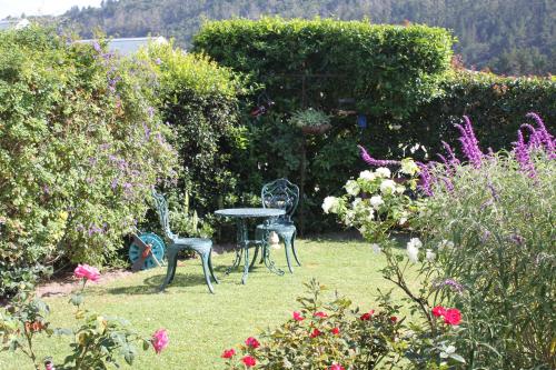 a table and chairs in a garden with flowers at Hubbs Place in Sedgefield