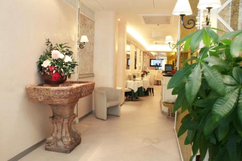 una habitación con una mesa con un jarrón de flores en Hotel Valle, en Roma