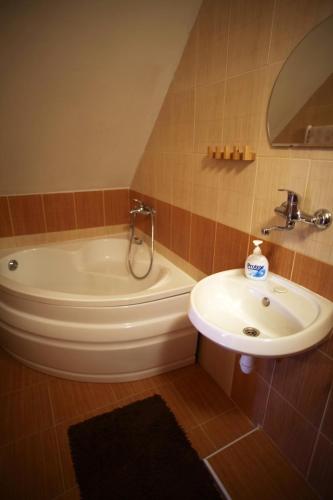 a bathroom with a sink and a tub and a toilet at Penzión Ľadová in Stratená