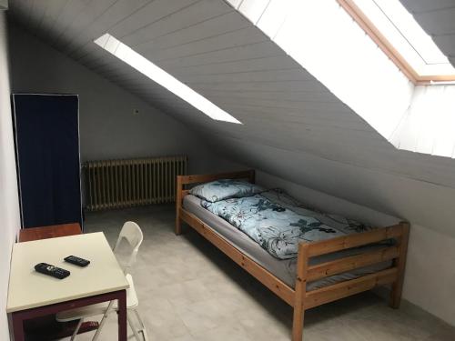 a bedroom with a bed in a attic with a skylight at Pension JuRa in Gronau
