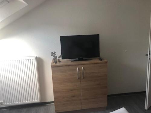 a flat screen tv sitting on top of a wooden cabinet at Hotel Lamm in Waiblingen