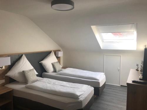 a hotel room with two beds and a skylight at Hotel Lamm in Waiblingen