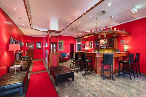 a bar in a room with red walls at Hotel Servatius in Cologne
