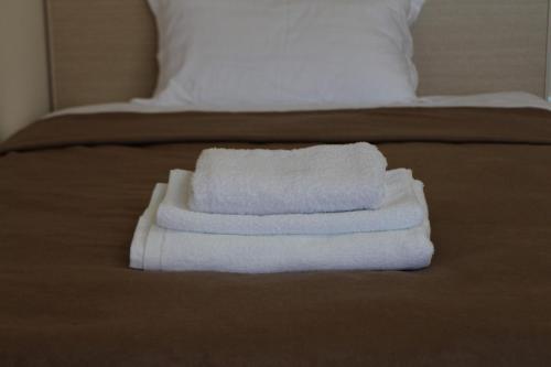 two towels are stacked on top of a bed at Апарт отель Welcome in Taldykorgan
