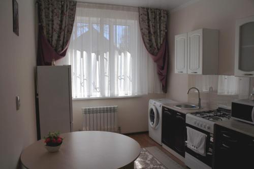 a small kitchen with a table and a window at Апарт отель Welcome in Taldykorgan