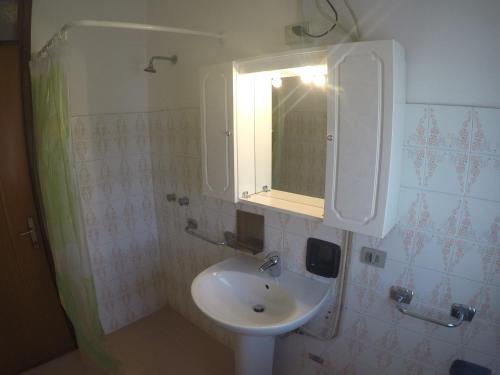 un bagno con lavandino e specchio di Condominio Commerciale a Caorle