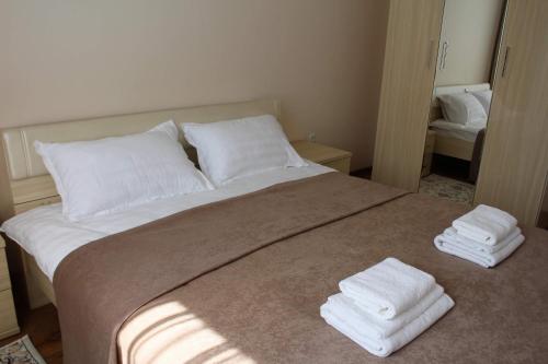 a bedroom with a bed with two towels on it at Апарт отель Welcome in Taldykorgan