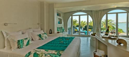 una camera con un grande letto e vista sull'oceano di Calypso Villas ad Amoudi