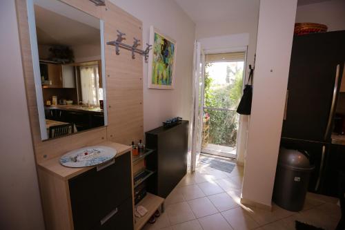 a kitchen with a sink and a mirror and a door at Pine-Tree Apt w/ Private Garden 50 m from the Sea in Golem