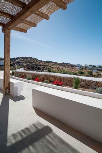 a white bench on a patio with a view at Almyra Guest Houses in Paraga