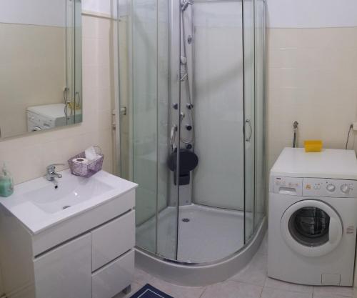 a bathroom with a shower and a washing machine at Apartamento Balsa in Viseu