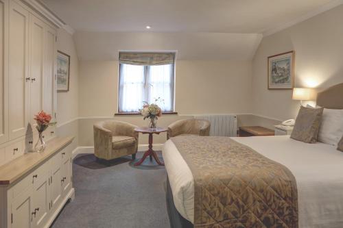 a hotel room with a bed and a table and chairs at The Tollgate Bed & Breakfast in Steyning