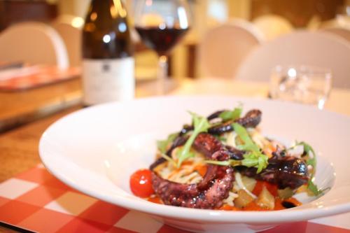a plate of food on a table with a glass of wine at Sud Hôtel Restaurant in Bastia