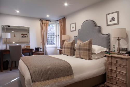 a bedroom with a large bed with a desk and a desk at The Roseate Edinburgh - Small Luxury Hotels of the World in Edinburgh