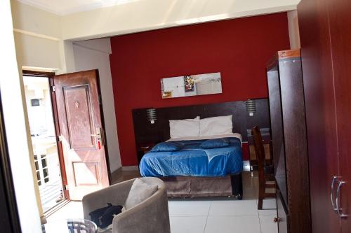 a bedroom with a bed and a red wall at Le Victoria in Vila-de-Santiago-Maior
