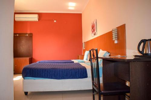 a hotel room with a bed and a desk and a desk at Le Victoria in Vila-de-Santiago-Maior