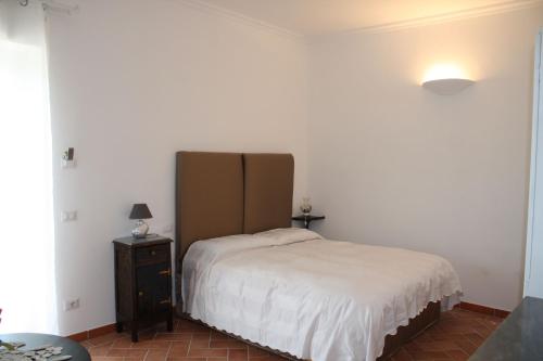 a bedroom with a white bed and a nightstand and a bed sidx sidx sidx at Ippocastano B&B in Viterbo