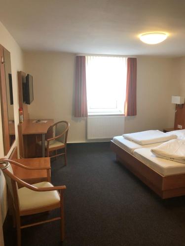 Zimmer mit 2 Betten, einem Schreibtisch und einem Fenster in der Unterkunft Döbelts Hotel Schützenhaus Jessen in Jessen